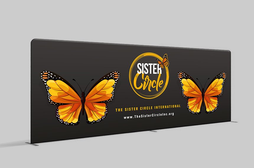 Wide black stage-barrier banner with two orange monarch butterflies and Sister Circle logo, designed by Rahat Abir.